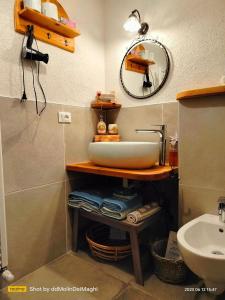 een badkamer met een wastafel en een spiegel bij MolinDeiMaghi in Fondo