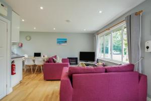 - un salon avec deux canapés violets et une table dans l'établissement Cornish Holiday - 91 Hengar Manor, à Saint Tudy