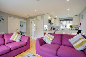 un salon avec deux canapés violets et une cuisine dans l'établissement Cornish Holiday - 91 Hengar Manor, à Saint Tudy