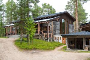 a log home with a porch on a dirt road at Holiday Village Himmerki in Posio