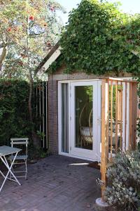 Habitación con jardín, puerta y silla en 1 for 2, en Nederhorst den Berg