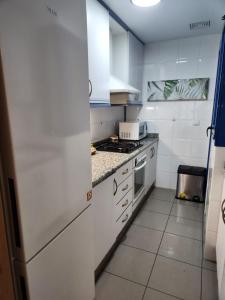 a white kitchen with a stove and a refrigerator at PATACONA BEACH in Valencia