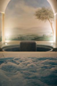 una vasca da bagno in una stanza con un dipinto di Apparthotel Sonnwies a Selva dei Molini