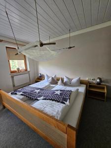 Schlafzimmer mit einem Bett und einer Hängematte, die von der Decke hängt in der Unterkunft Pension Schatzkisterl in Zwiesel