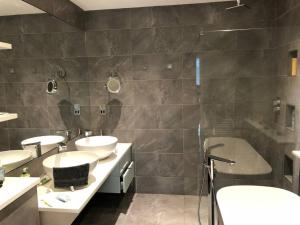 łazienka z 2 umywalkami, wanną i 2 lustrami w obiekcie Slate House w mieście Ballybunion