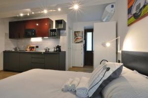 una camera con letto bianco e una cucina di Special 10 - Comfort and Style in the Heart of Historic Turin Center a Torino