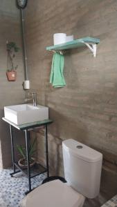 uma casa de banho com um WC branco e um lavatório. em La casita del lago em Ypacarai