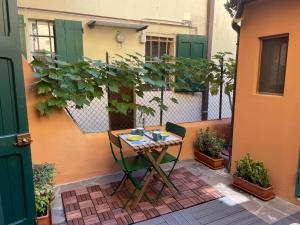 uma mesa e cadeira num pátio com plantas em Bella Bologna em Bolonha