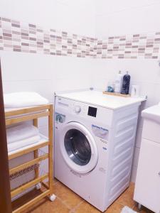 una lavatrice e un'asciugatrice in una lavanderia di Apartmán CENTRAL, self check in 24 h a Banská Bystrica