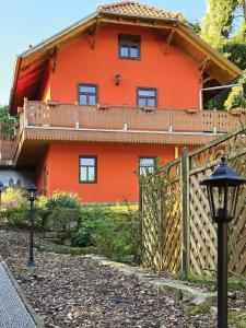 ein orangenes Haus mit einem Zaun und einem Tor in der Unterkunft Ferienhaus Nicole in Quedlinburg
