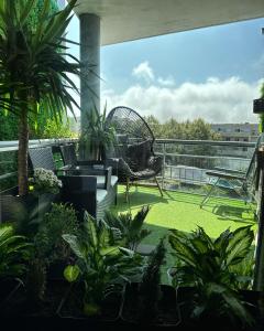 un patio con una silla y plantas en un balcón en Private Bedroom with Balcony & Private Bathroom in Modern Shared Apartment - King & Queen size bed, en Vila Nova de Gaia