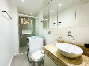 a white bathroom with a sink and a toilet at Studio Duque Master in Porto Alegre +16 photos