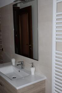 y baño con lavabo blanco y espejo. en B&b Mamì en Potenza