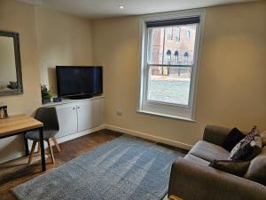 a living room with a couch and a tv and a window at Carlisle City Centre The Gavel in Carlisle