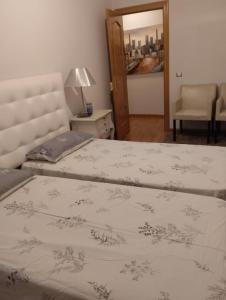 1 Schlafzimmer mit 2 Betten, einem Stuhl und einem Spiegel in der Unterkunft Alba de Tormes Salamanca Piso de 2 habitaciones 3 camas in Alba de Tormes