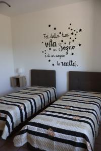 - une chambre avec 2 lits avec des mots sur le mur dans l'établissement B&b Mamì, à Potenza