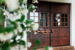 eine Holztür mit einem Fenster auf einem Haus in der Unterkunft Upington African Vineyard Boutique Hotel & SPA in Kanoneiland