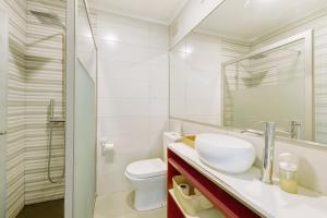 a white bathroom with a sink and a toilet at Above the Trees Close to the Sea in Estoril +13 photos