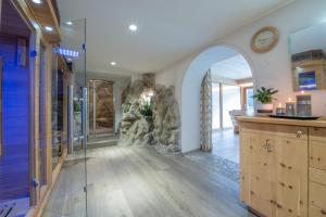 a home hallway with an archway and a stone wall at Hotel Lago della Creta in San Vigilio Di Marebbe