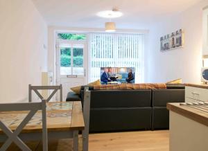 two men sitting in a living room with a couch at Newly refurbished flat, 1 min from Galgorm resort in Cullybackey