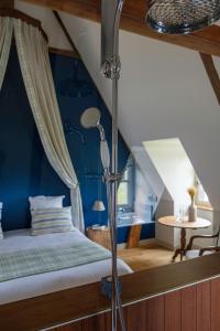 a bedroom with a bed with a blue wall at Le Domaine de Ravenoville - Pierres d'Histoire in Ravenoville