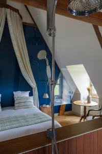 Schlafzimmer mit einem Bett mit blauer Wand in der Unterkunft Le Domaine de Ravenoville - Pierres d'Histoire in Ravenoville