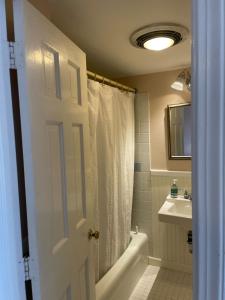 a bathroom with a white shower curtain and a sink at Cooper Hill Inn in West Dover