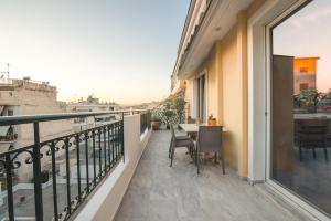 a balcony with a table and chairs on a building at Vanesa's House in Athens