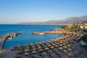 Nana Golden Beach All Inclusive Resort & Spa في خيرسونيسوس: مجموعة مظلات على شاطئ بجانب الماء