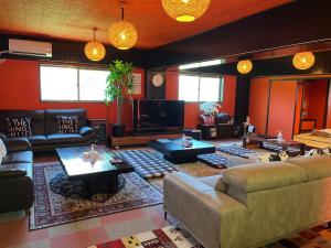 贝冢市背包客机场旅馆的客厅里有一张沙发和一台电视