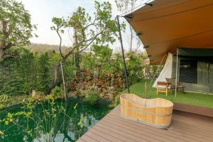 an outdoor deck with a tent and a chair at CAMP CAYLA - EDEN in Chiang Mai