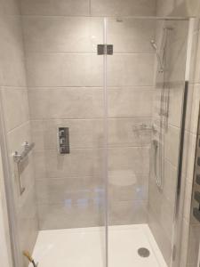 uma casa de banho com um chuveiro e uma porta de vidro em Fly By em Duxford