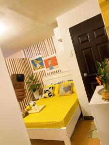 een kleine slaapkamer met een geel bed in een kamer bij Bulacan Staycation At Urban Deca Homes Marilao in Marilao