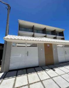 um edifício com três portas de garagem em frente em Casa Pero Oficial em Cabo Frio