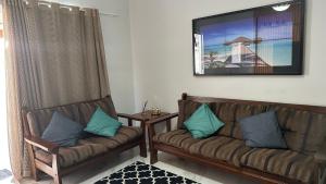 uma sala de estar com dois sofás de couro e uma mesa em Casa Pero Oficial em Cabo Frio