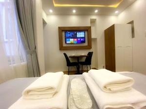 a bedroom with a bed and a table and a tv at İSLAND APARTİSTANBUL in Istanbul