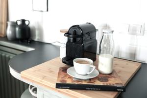 a cup of coffee on a cutting board with a coffee maker at Casa Palfy in Oslip