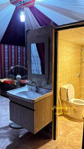 een badkamer met een wastafel en een toilet bij Traditions of Wadi Rum camp & jeep tour in Wadi Rum