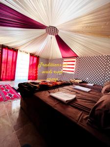 een kamer met een bed in een tent bij Traditions of Wadi Rum camp & jeep tour in Wadi Rum