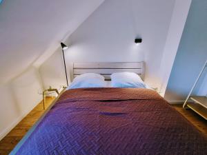 1 dormitorio con 1 cama grande con manta morada en Hell & ruhig, 200m zur U-Bahn, en Ahrensburg