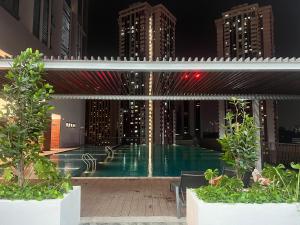 a swimming pool in the middle of a city at night at Cozy luxury couple studio apartment chambers kl klcc kl tower view in Kuala Lumpur