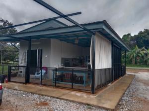 a metal pavilion with a table in front of it at De Hampar Homestay in Kampong Merbok
