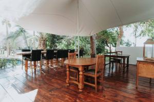 a dining room with wooden tables and chairs at Upington African Vineyard Boutique Hotel & SPA in Kanoneiland