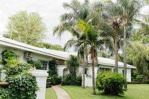 a house with palm trees in front of it at Upington African Vineyard Boutique Hotel & SPA in Kanoneiland