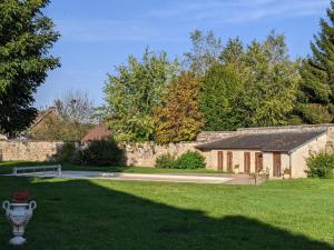 a house with a stone wall and a yard at Maison de campagne in Ambleny