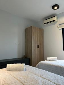 a bedroom with two beds and a wooden cabinet at MODERNO DEPARTAMENTO PARA 3-4 PERSONAS, MUY BIEN UBICADO in Santiago del Estero