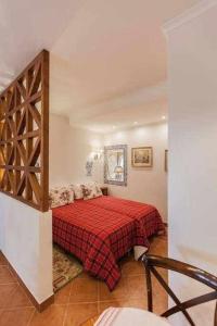 a bedroom with a bed with a red blanket at Villa Estefânia em Sintra in Sintra