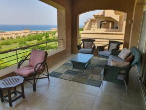 einen Balkon mit Stühlen, einem Tisch und Meerblick in der Unterkunft Your Perfect Getaway with a Breathtaking Beach View in Ain Suchna