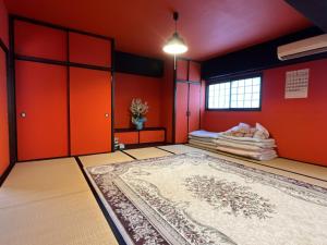 a room with red walls and a rug on the floor at Airport Osaka in Kaizuka