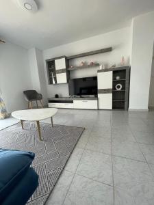 a living room with a table and a kitchen at Casa de Perlas in El Campello